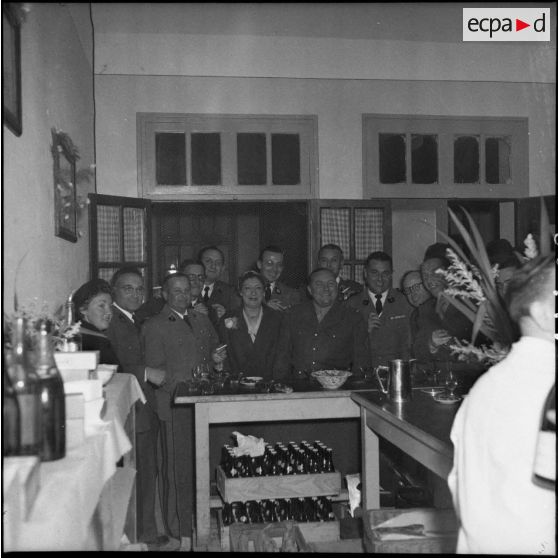 Photographie de groupe des personnels civils et militaires autour du bar.