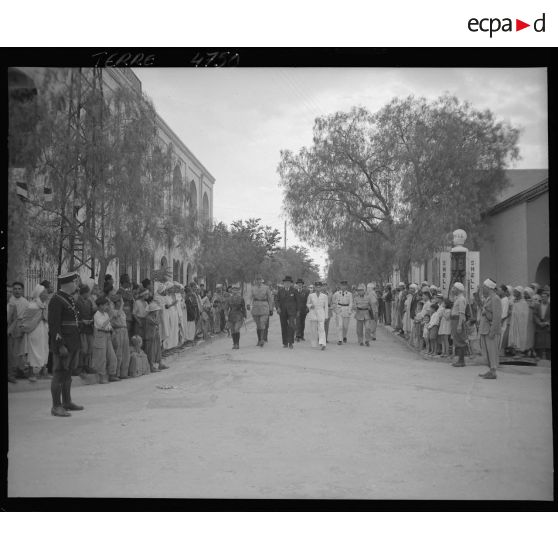 André Diethelm et les personnalités qui l'accompagnent passent dans les rues de Bou Saada.