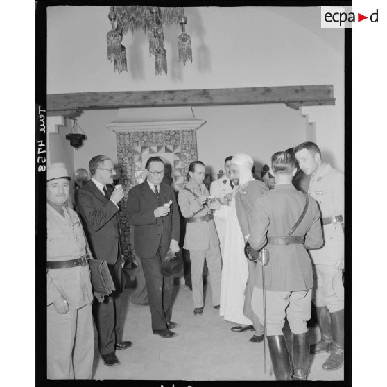 André Diethelm entre dans un café maure lors de sa visite à l'école des élèves officiers indigènes de Bou Saada.