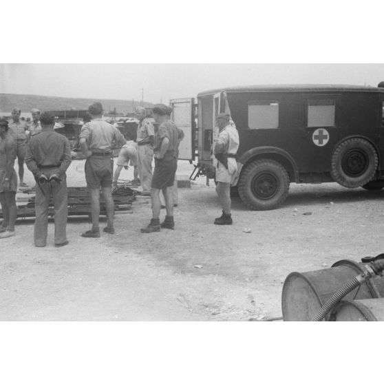 Sur un quai utilisé par les hydravions Dornier DO-24 du Seenotstaffel 7, une ambulance et des brancards attendent des blessés d'une unité de transport.