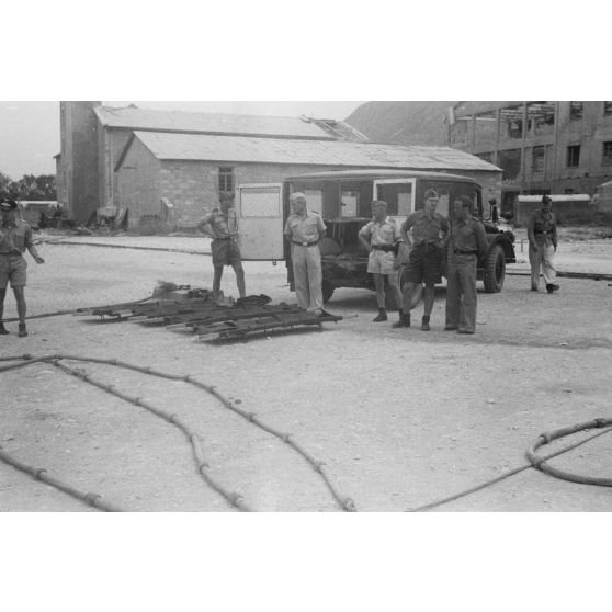 Sur un quai utilisé par les hydravions Dornier DO-24 du Seenotstaffel 7, une ambulance et des brancards attendent des blessés d'une unité de transport.
