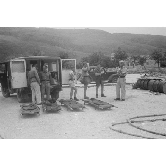 Sur un quai utilisé par les hydravions Dornier DO-24 du Seenotstaffel 7, une ambulance et des brancards attendent des blessés d'une unité de transport.