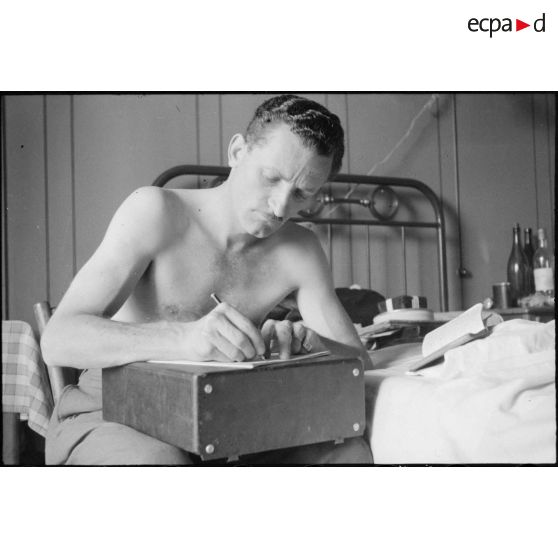 Le photographe du Service cinématographique de l'armée (SCA) Jacques Belin rédige un compte-rendu de prise de vues.