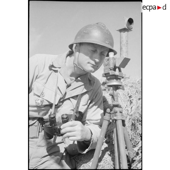 Un officier de tir de l'Armée B, équipé de jumelles et d'un binoculaire, à son poste d'observation installé à proximité du fort Lomont.