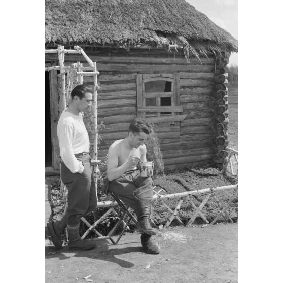 Des soldats de la Luftwaffe s'accordent une pause lors de la restauration d'une isba réquisitionnée.
