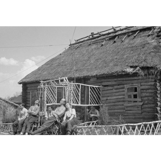 Des soldats de la Luftwaffe s'accordent une pause lors de la restauration d'une isba réquisitionnée.