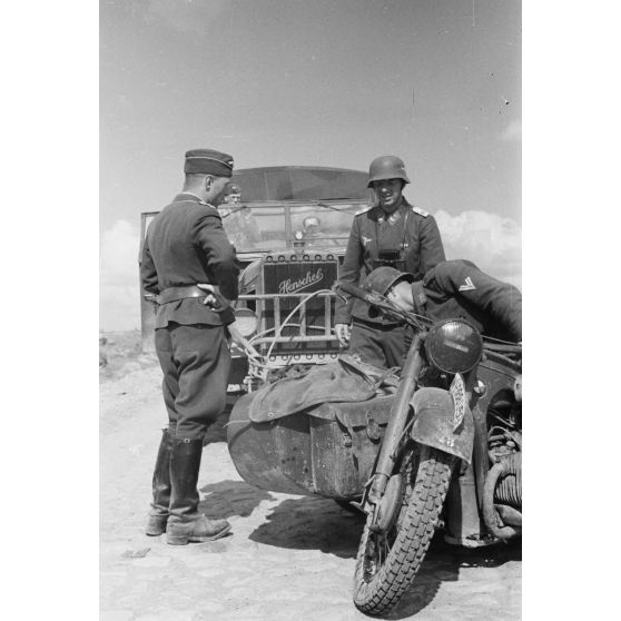 Mouvement d'une batterie de FlaK, un side-car BMW R12 devant un camion Henschel 33D.