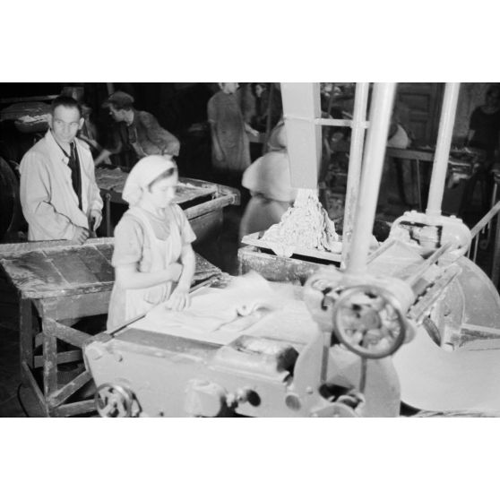 Des femmes russes travaillent dans une buiscuiterie sous le contrôle des contre-maitres allemands.