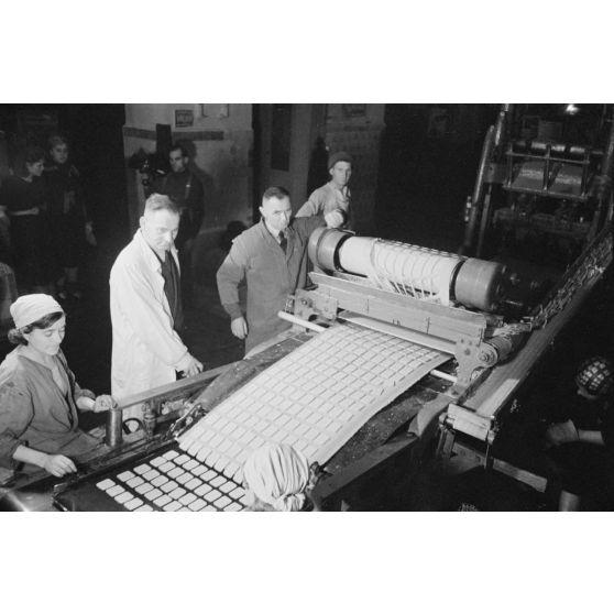 Des femmes russes travaillent dans une buiscuiterie sous le contrôle des contre-maitres allemands.