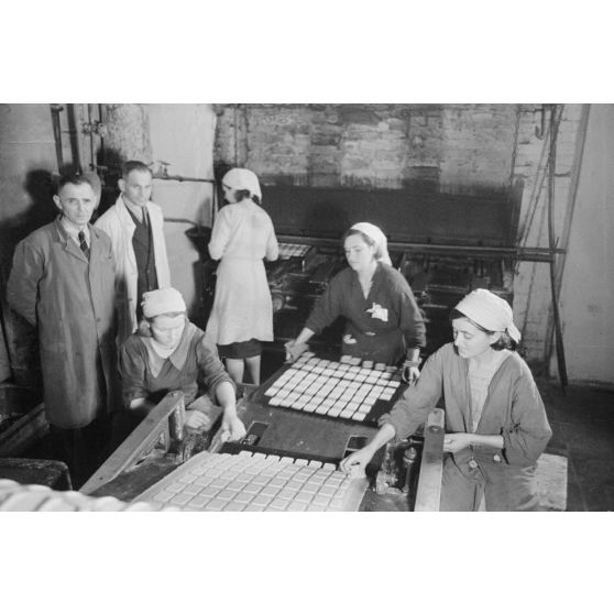 Des femmes russes travaillent dans une buiscuiterie sous le contrôle des contre-maitres allemands.