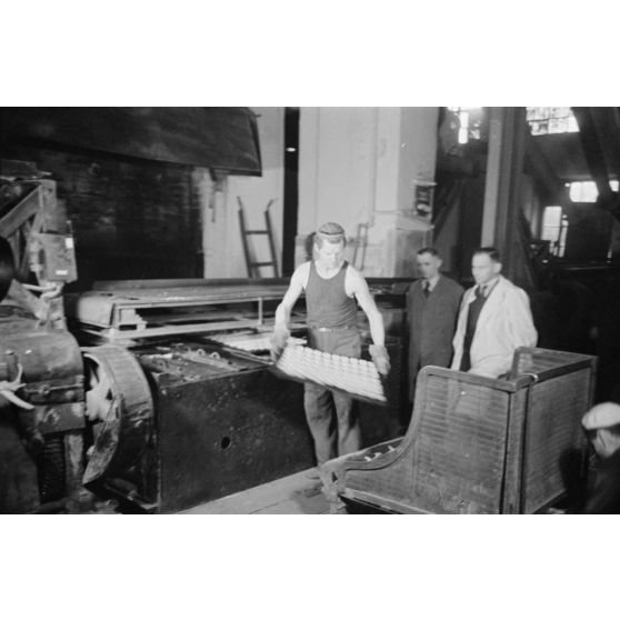 Des femmes russes travaillent dans une buiscuiterie sous le contrôle des contre-maitres allemands.