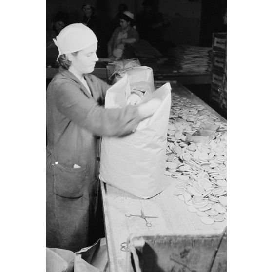 Des femmes russes travaillent dans une buiscuiterie sous le contrôle des contre-maitres allemands.