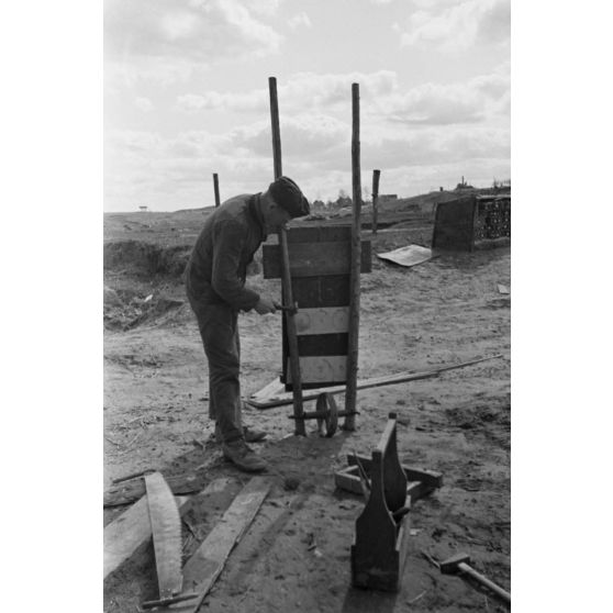 Les servants d'une pièce d'artillerie allemande de 10,5 cm FH 18 (Feldhaubitze) construisent une brouette pour le transport des munitions.