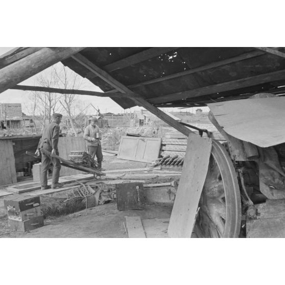 Les servants d'une pièce d'artillerie allemande de 10,5 cm FH 18 (Feldhaubitze) construisent une brouette pour le transport des munitions.