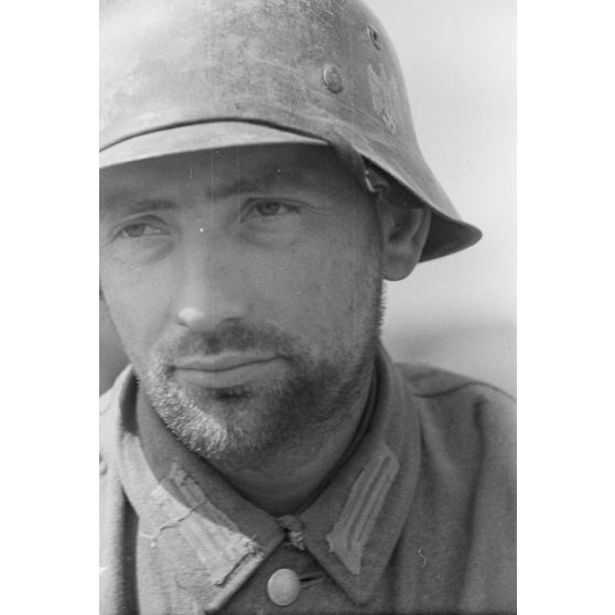 Portrait d'un fantassin casqué en poste dans une tranchée défensive allemande.