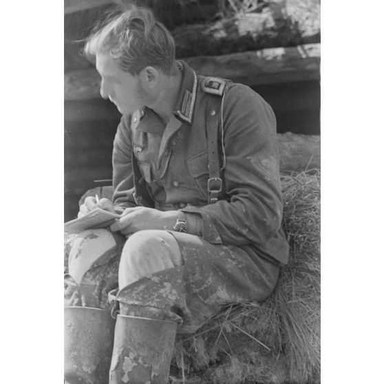 Un sous-officier allemand, en poste dans une tranchée défensive, rédige une lettre (courrier).