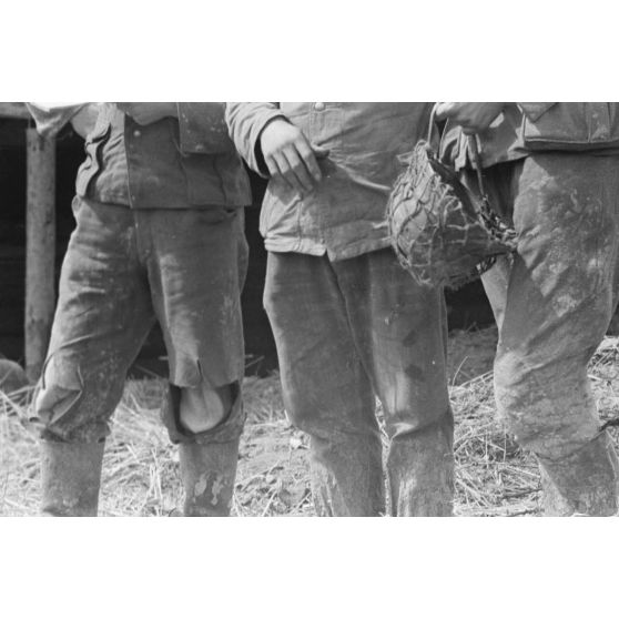 Les uniformes délabrés de fantassins allemands en position défensive dans une tranchée.