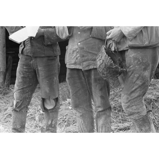 Les uniformes délabrés de fantassins allemands en position défensive dans une tranchée.