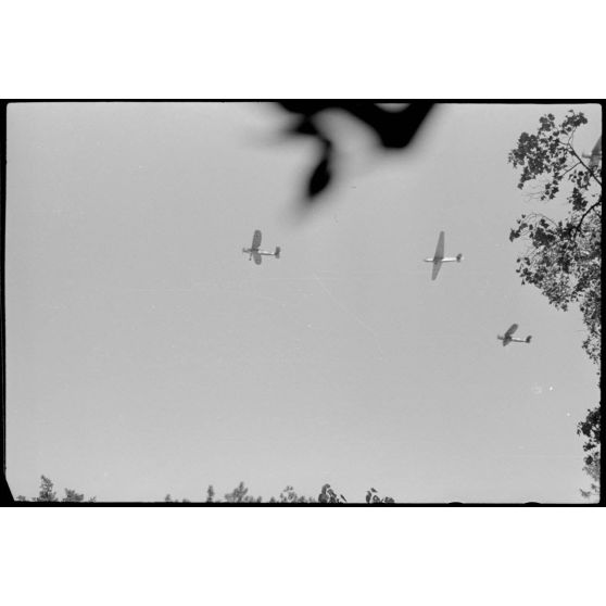 Depuis une maison réquisitionnée où s'est implanté l'état-major du Luftlandegeschwader 1, vue sur un planeur DFS-230 et deux tracteurs Henschel Hs-126 viennent de décoller.