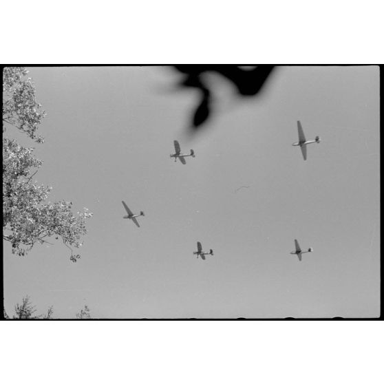 Depuis une maison réquisitionnée où s'est implanté l'état-major du Luftlandegeschwader 1, vue sur trois planeurs DFS-230 et deux tracteurs Henschel Hs-126 viennent de décoller.