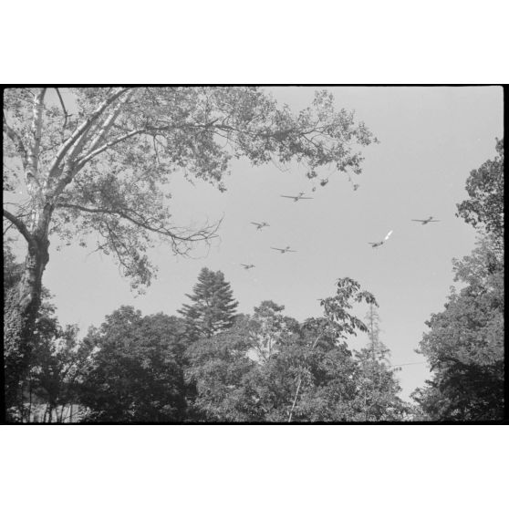 Depuis une maison réquisitionnée où s'est implanté l'état-major du Luftlandegeschwader 1, vue sur un planeur DFS-230 et deux tracteurs Henschel Hs-126 viennent de décoller.