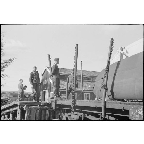 Sur le terrain de Gardermoen, un capitaine du du 8./LLG 1 (Lulftlandegeschwader 1) et un reporter de la section de propagande aéroportée assistent au chargemnet de planeurs DFS-230 sur des wagons de chemin de fer.