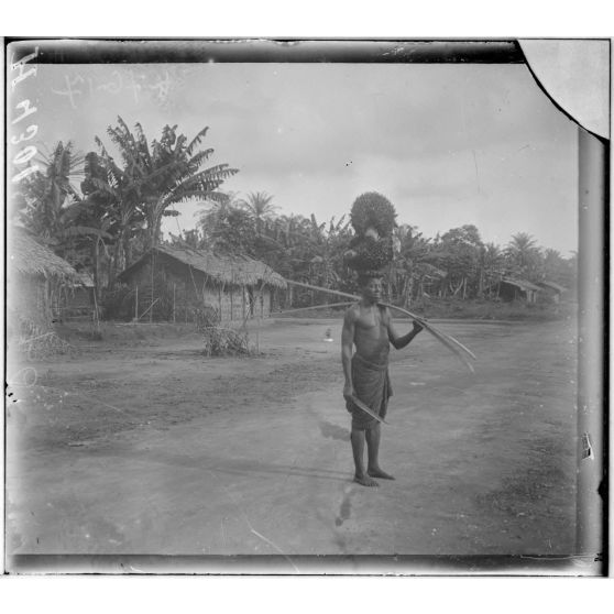 Kaké. Indigène portant des régimes de palmiers à huile. [légende d'origine]