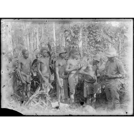 Plantation de l'Hermannshof. Hommes apportant le latex récolté. [légende d'origine]