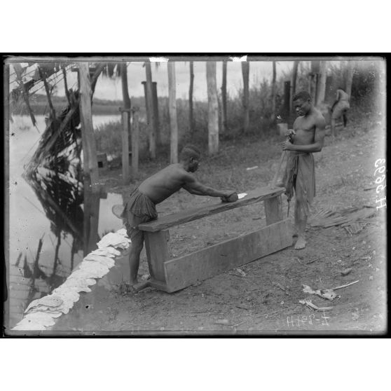 Akonolinga. Roulage en galettes du latex coagulé. [légende d'origine]