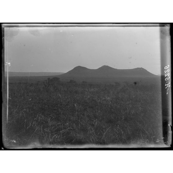 Route de N'Gaoundéré à Garoua. A 1/2h de Mai-Bournou, aspect de la contrée , pitons isolés. [légende d'origine]