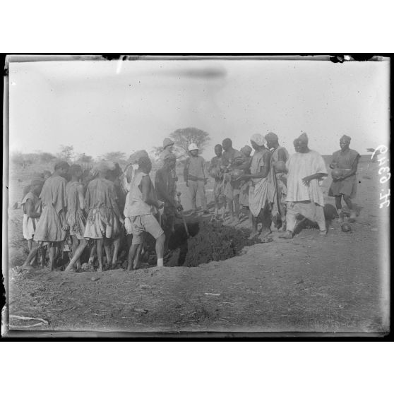 Route de Garoua à Maroua. Badiouma. Indigènes pétrissant le banko pour la construction des cases. [légende d'origine]