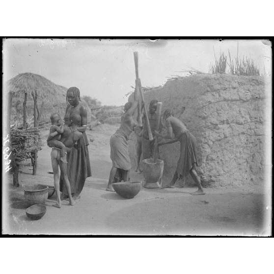 Route de Mora à Kousseri. Oulou. Pilage du mil. [légende d'origine]