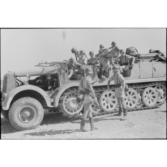 Un semi-chenillé Sd.kfz.7 s'apprête à tracter une pièce de 8,8 cm FlaK que les artilleurs viennent d'atteler.