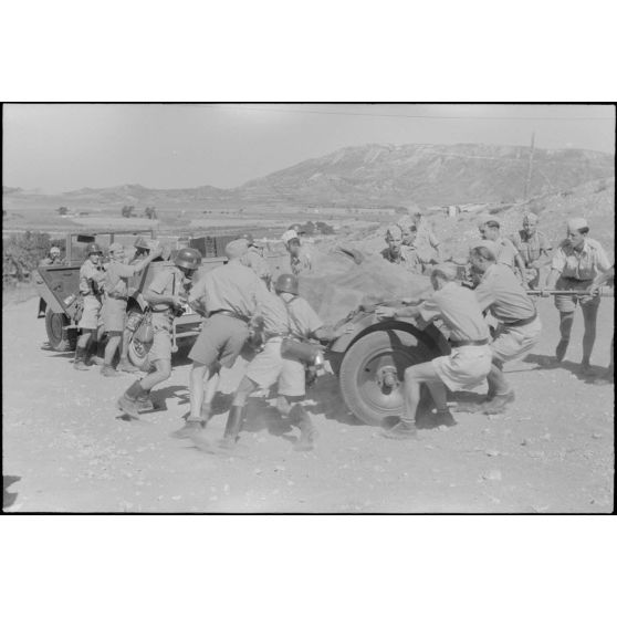 Un semi-chenillé Sd.kfz.7 s'apprête à tracter une pièce de 8,8 cm FlaK que les artilleurs viennent d'atteler.