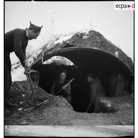 Des soldats construisent un abri de campagne.