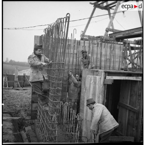 Des soldats construisent des fortifications de béton.