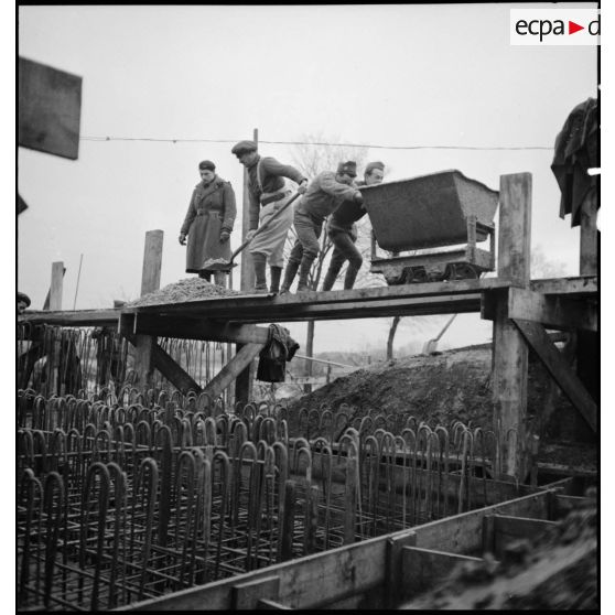 Des soldats construisent des fortifications de béton.