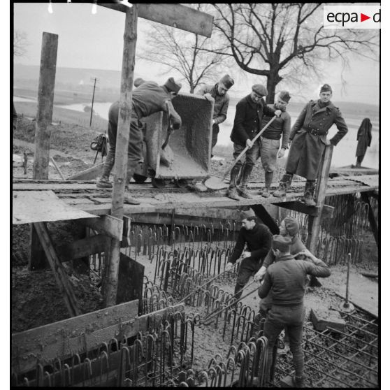 Des soldats construisent des fortifications de béton.