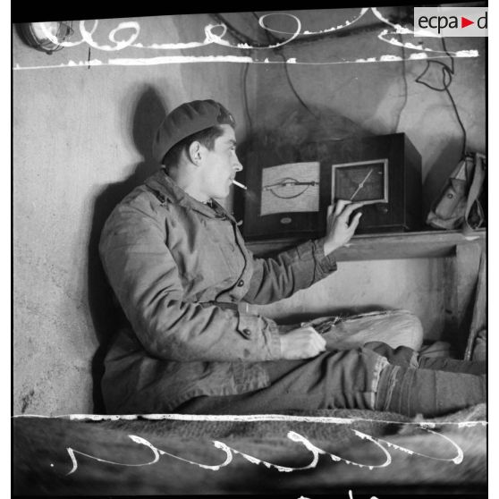 Plan moyen d'un soldat d'un régiment d'infanterie de forteresse (RIF) qui écoute la radio dans une chambrée d'un ouvrage de la ligne Maginot.