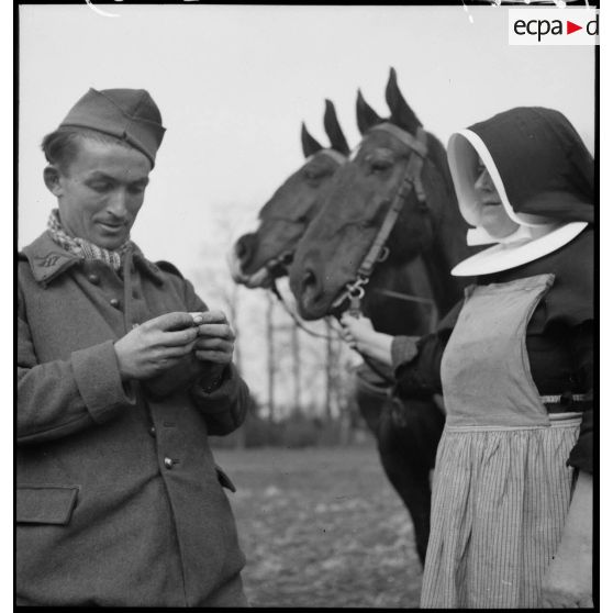 Un fantassin, probablement affecté au 117e RI (régiment d'infanterie), qui participe aux travaux des champs en Alsace, se trouve en compagnie d'une religieuse.