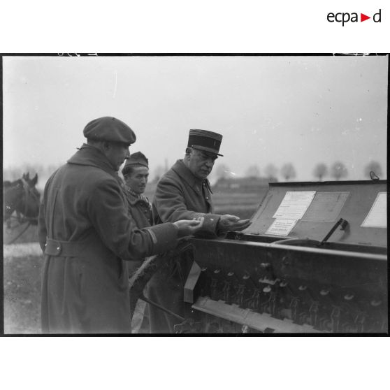 Deux officiers de la 5e armée sont photographiés devant une machine agricole.