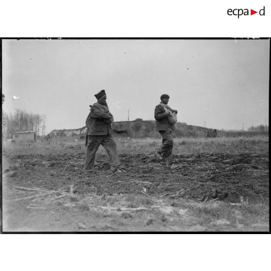 Des soldats de la 5e armée sèment dans un champ.