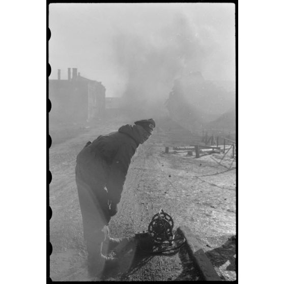 Peu avant le départ des troupes allemandes de Wjasma, un officier du Génie prépare la destruction d'un pont à l'aide d'explosifs.