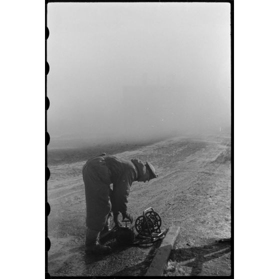 Peu avant le départ des troupes allemandes de Wjasma, un officier du Génie prépare la destruction d'un pont à l'aide d'explosifs.