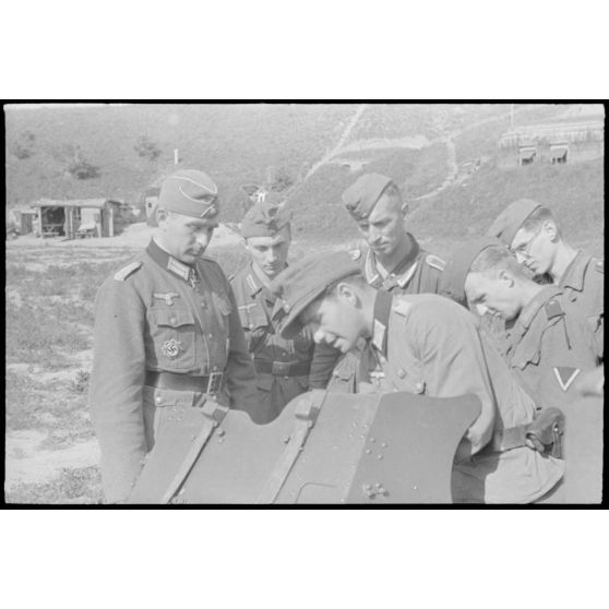Le commandant (Major) Hans Müller apporte son expérience du terrain à des fantassins en formation derrière une pièce de 3,7 cm Pak 36/37.