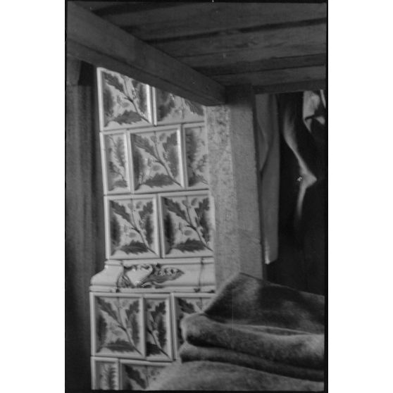 Dans un abri de campagne de la 205. Infanterie-Division, un poêle à bois en céramique attire le reporter.