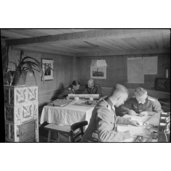 Dans un abri de campagne de la 205. Infanterie-Division, le commandant (Major) Hans Müller travaille en compagnie d'un autre officier.