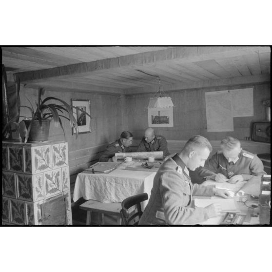 Dans un abri de campagne de la 205. Infanterie-Division, le commandant (Major) Hans Müller travaille en compagnie d'un autre officier.