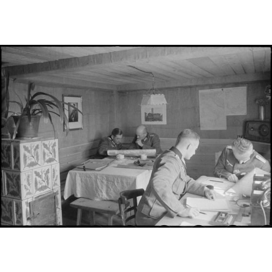 Dans un abri de campagne de la 205. Infanterie-Division, le commandant (Major) Hans Müller travaille en compagnie d'un autre officier.