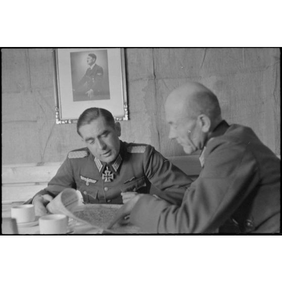 Dans un abri de campagne de la 205. Infanterie-Division, le commandant (Major) Hans Müller travaille en compagnie d'un autre officier.